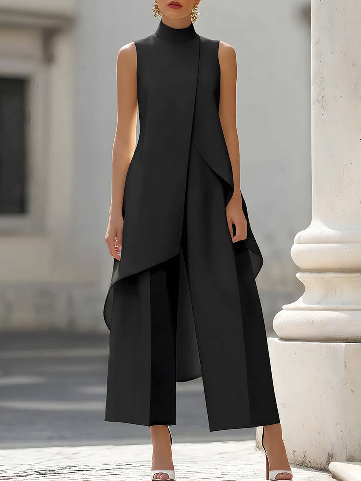 Version noire de l'ensemble, vue de face en plan taille-genoux, haut sans manches à col montant et pan asymétrique sur pantalon ample. 2