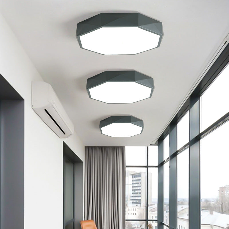 Trois plafonniers octogonaux gris de tailles différentes alignés au plafond d'un couloir vitré 2