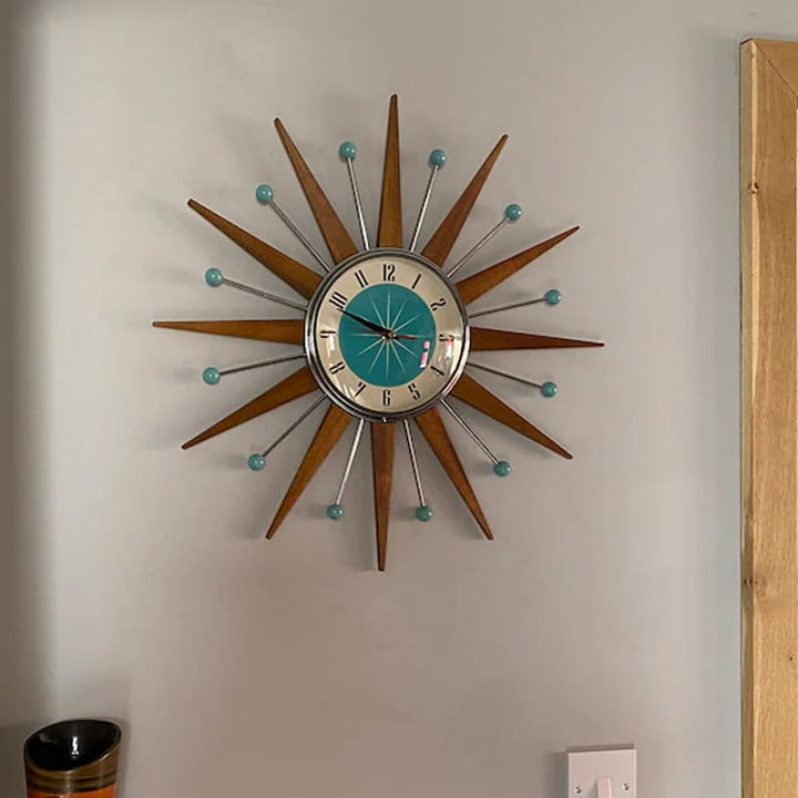 Horloge étoile accrochée dans une pièce, au-dessus d'une prise murale, près d'un montant de porte en bois clair. 5