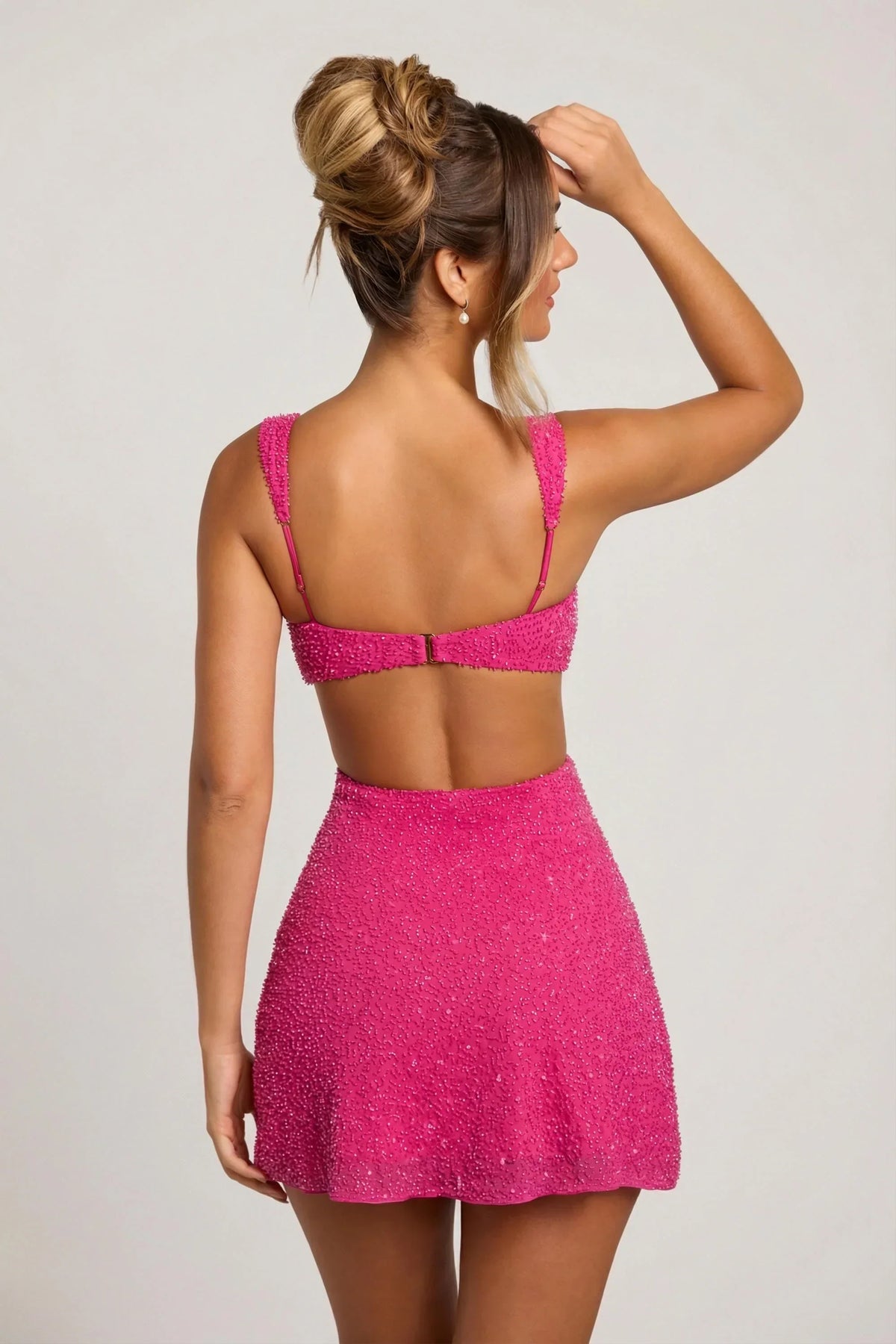 Gros plan de dos sur le dos ouvert de la robe rose, avec fermeture à agrafe et fines bretelles réglables. 3