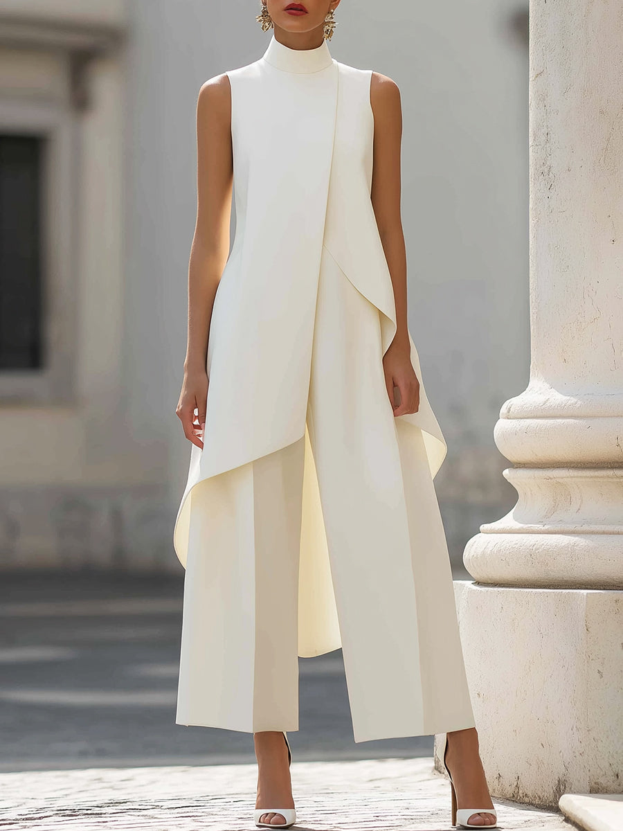 Version blanc crème portée de face devant une colonne claire, avec le pan asymétrique du haut qui retombe sur le pantalon large. 3