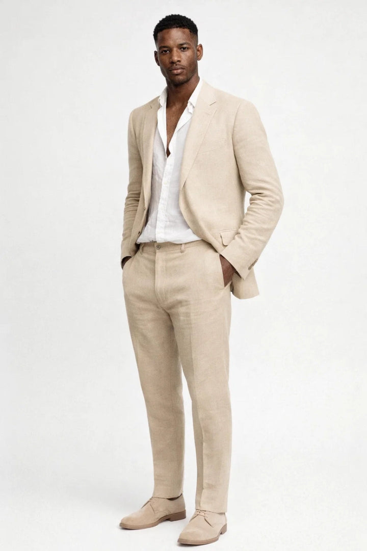 Mannequin en pied portant le costume beige sable avec chemise blanche et chaussures en daim assorties, une main dans la poche. 3