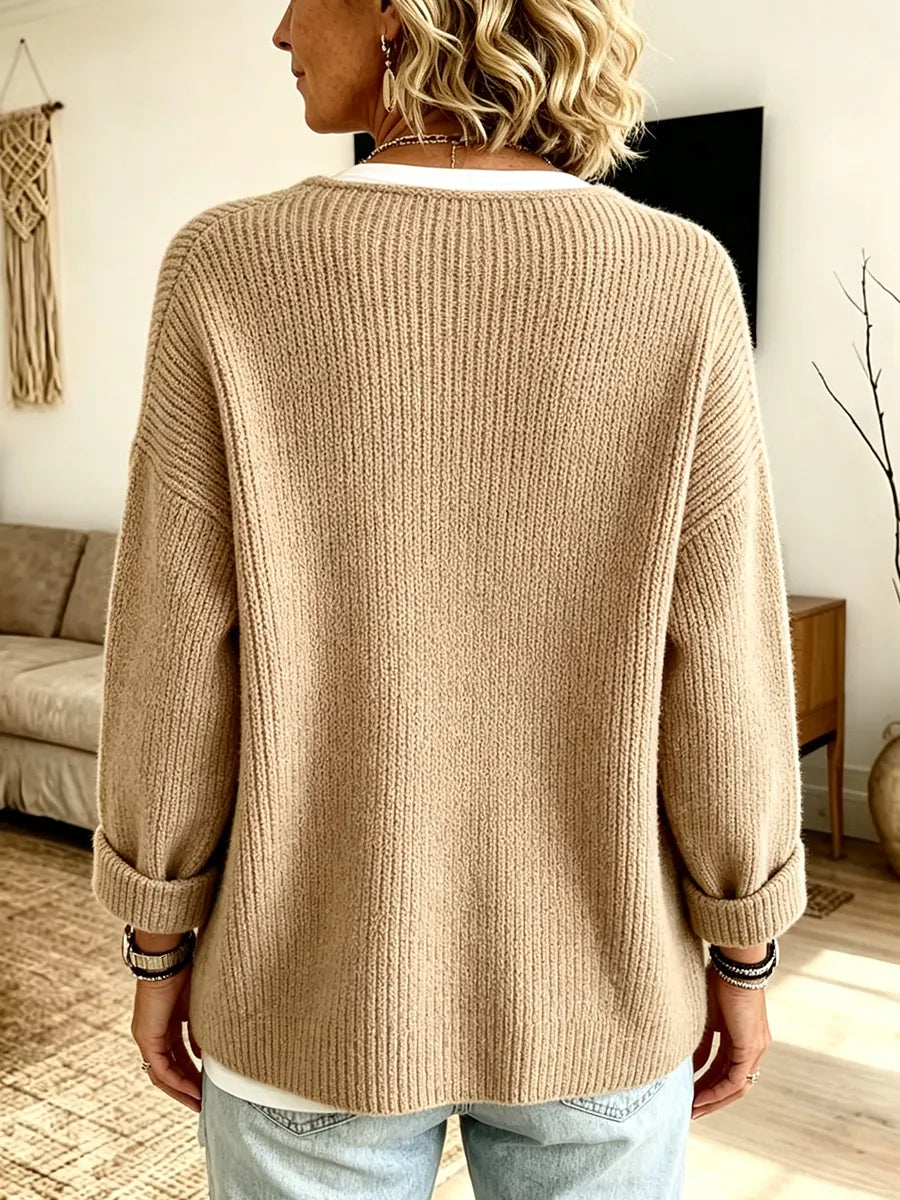 Dos du cardigan côtelé beige, manches retroussées, porté avec un jean clair par une femme 2