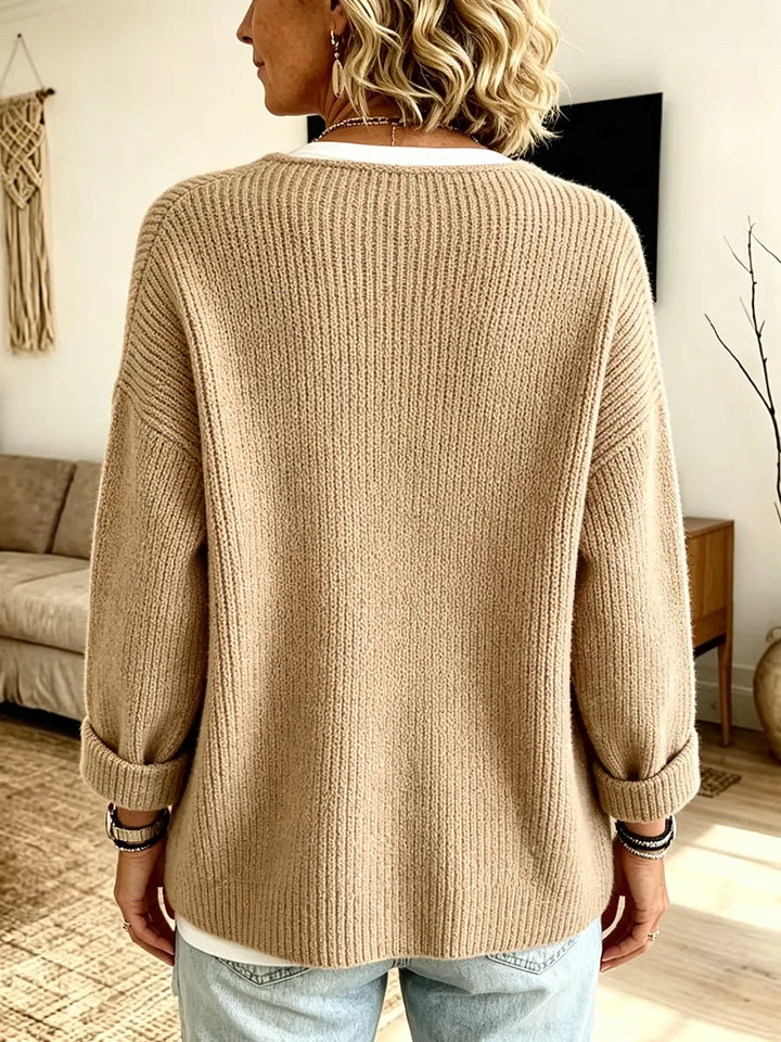 Dos du cardigan côtelé beige, manches retroussées, porté avec un jean clair par une femme 2