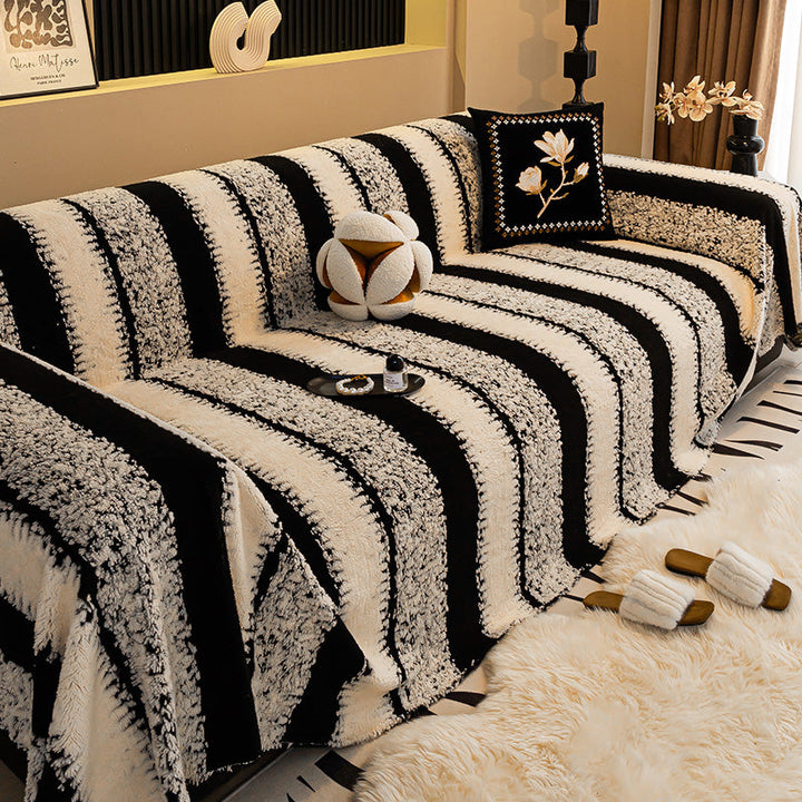 Canapé couvert d'une housse blanche et noire à larges rayures, avec coussin brodé de fleur 9