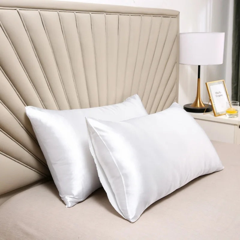 Deux taies satinées blanches installées sur un lit devant une tête de lit beige en éventail 3