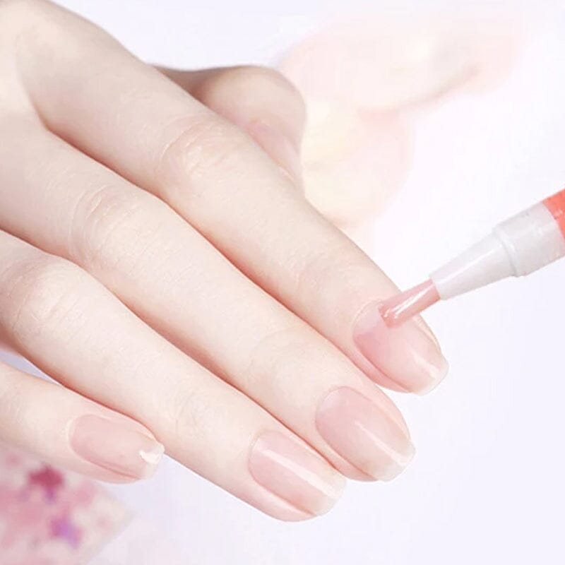 Main aux ongles roses lisses, pinceau du stylo appliquant l'huile sur le bord de l'ongle 11