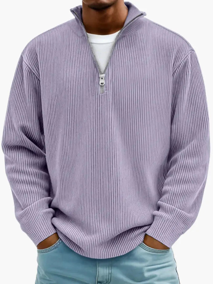 Homme portant le pull côtelé à col zippé en lilas, porté avec un t-shirt blanc et un jean bleu clair. 9