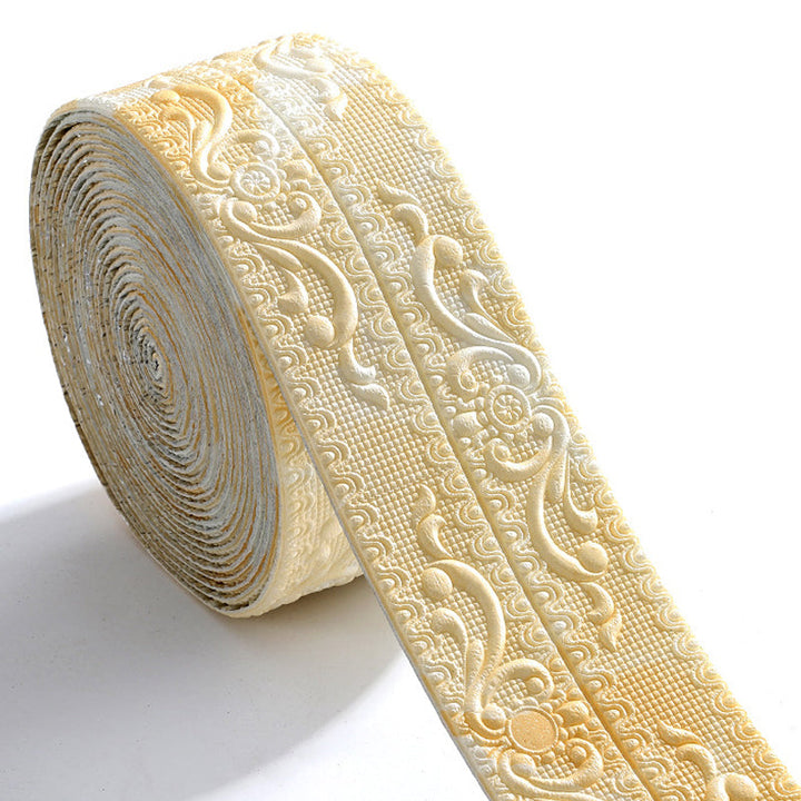 Rouleau de bordure crème nuancée de doré en relief, motifs floraux et volutes, posé sur fond blanc. 10