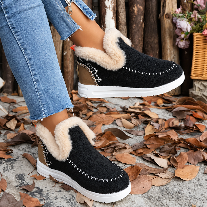Paire noire portée avec un jean sur des feuilles mortes, col en fausse fourrure beige et semelle blanche épaisse. 1