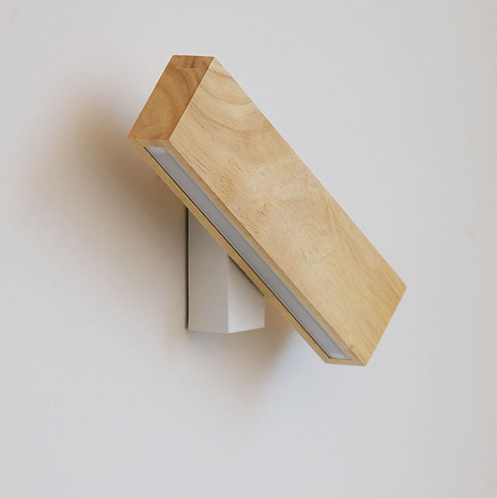 Applique éteinte, barre en bois inclinée sur son support blanc, vue de côté avec la bande diffusante visible. 13