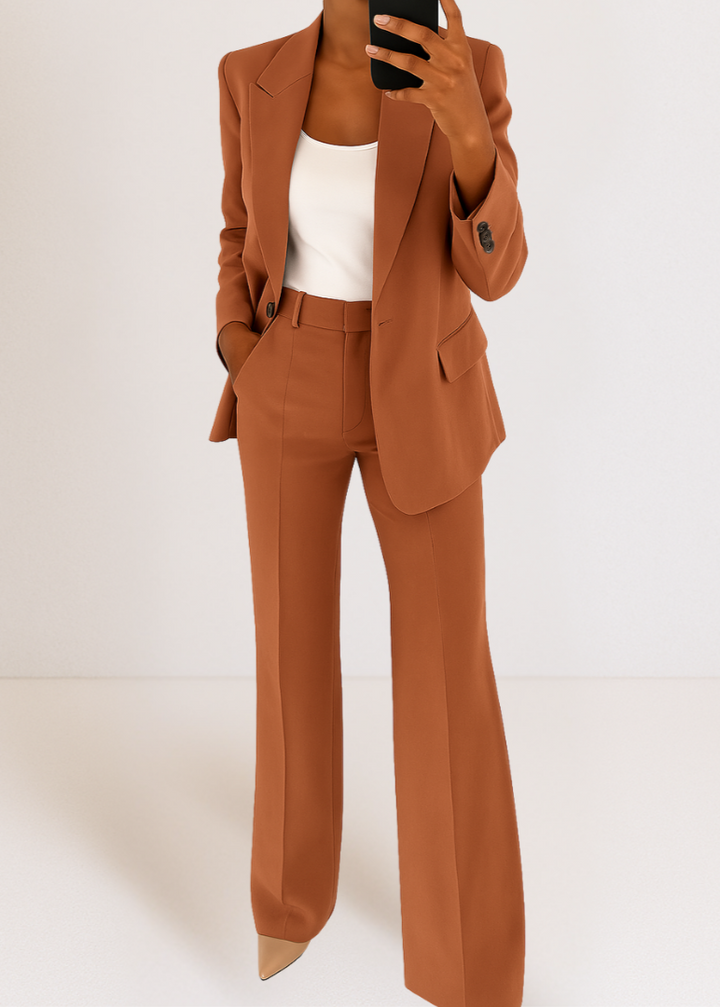 Femme en selfie miroir dans l'ensemble terracotta, blazer boutonné au col cranté, haut blanc et pantalon évasé à pli. 4