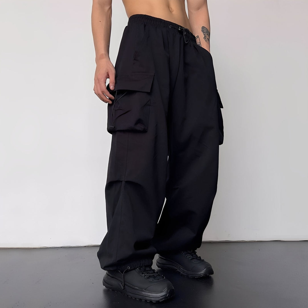 Version noire du pantalon cargo oversize, portée de trois quarts avec baskets noires 3