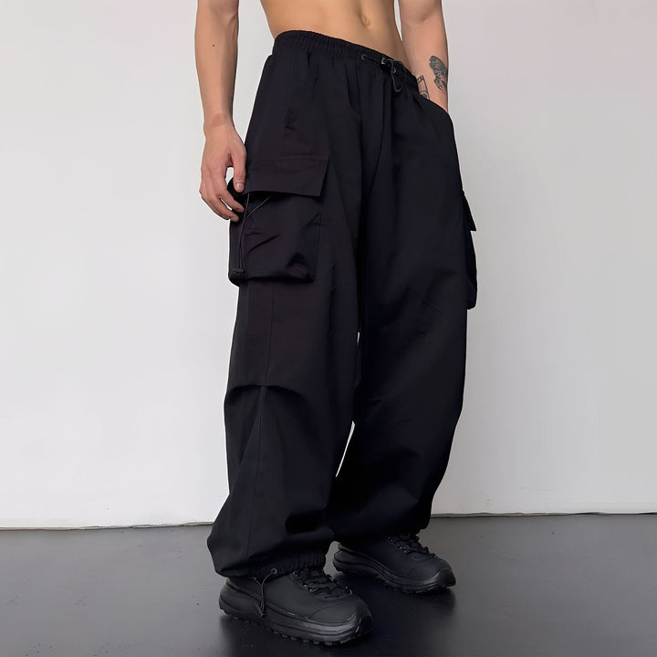 Version noire du pantalon cargo oversize, portée de trois quarts avec baskets noires 3