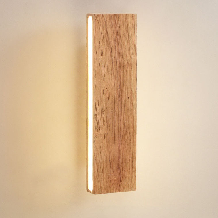 Gros plan sur le bois clair veiné de l'applique verticale, allumée, avec la bande lumineuse sur le bord gauche. 14