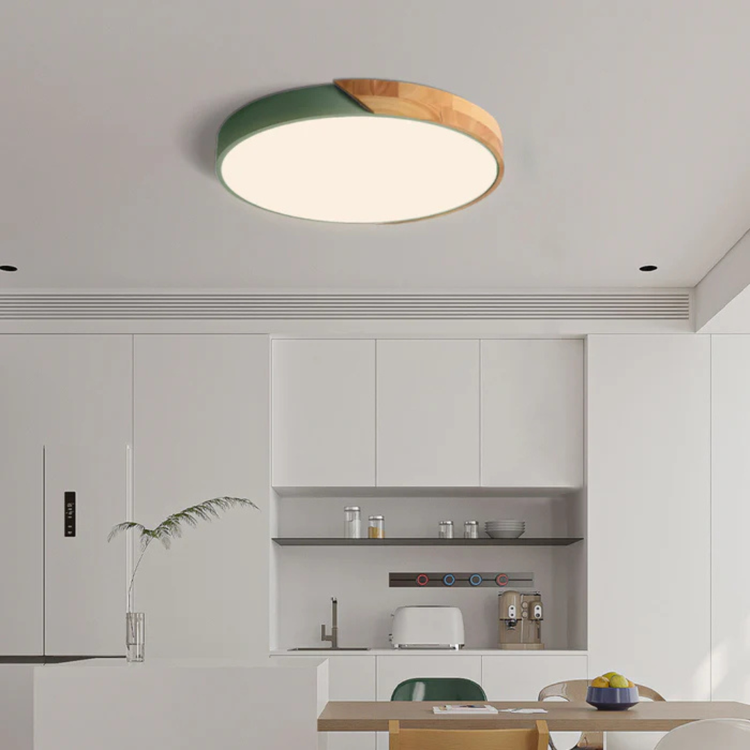 Plafonnier à coque verte et bois clair allumé au-dessus d'une cuisine blanche épurée 3