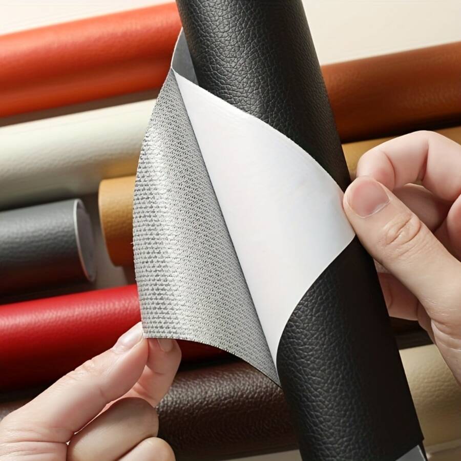 Mains décollant le dos gris adhésif d'un rouleau de cuir noir, d'autres rouleaux colorés derrière 1
