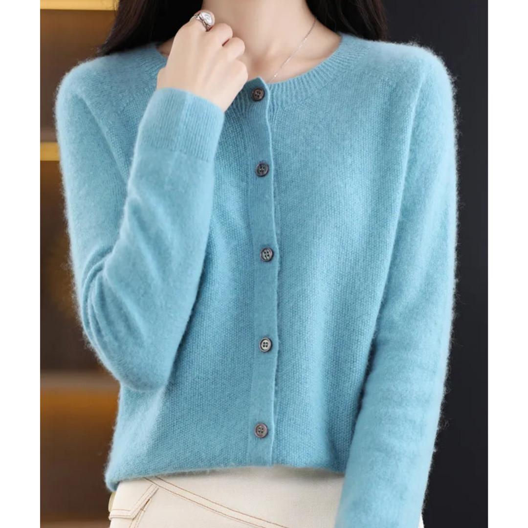 Cardigan bleu turquoise clair à col rond, cinq boutons, porté avec un pantalon crème, main relevée vers le col. 4