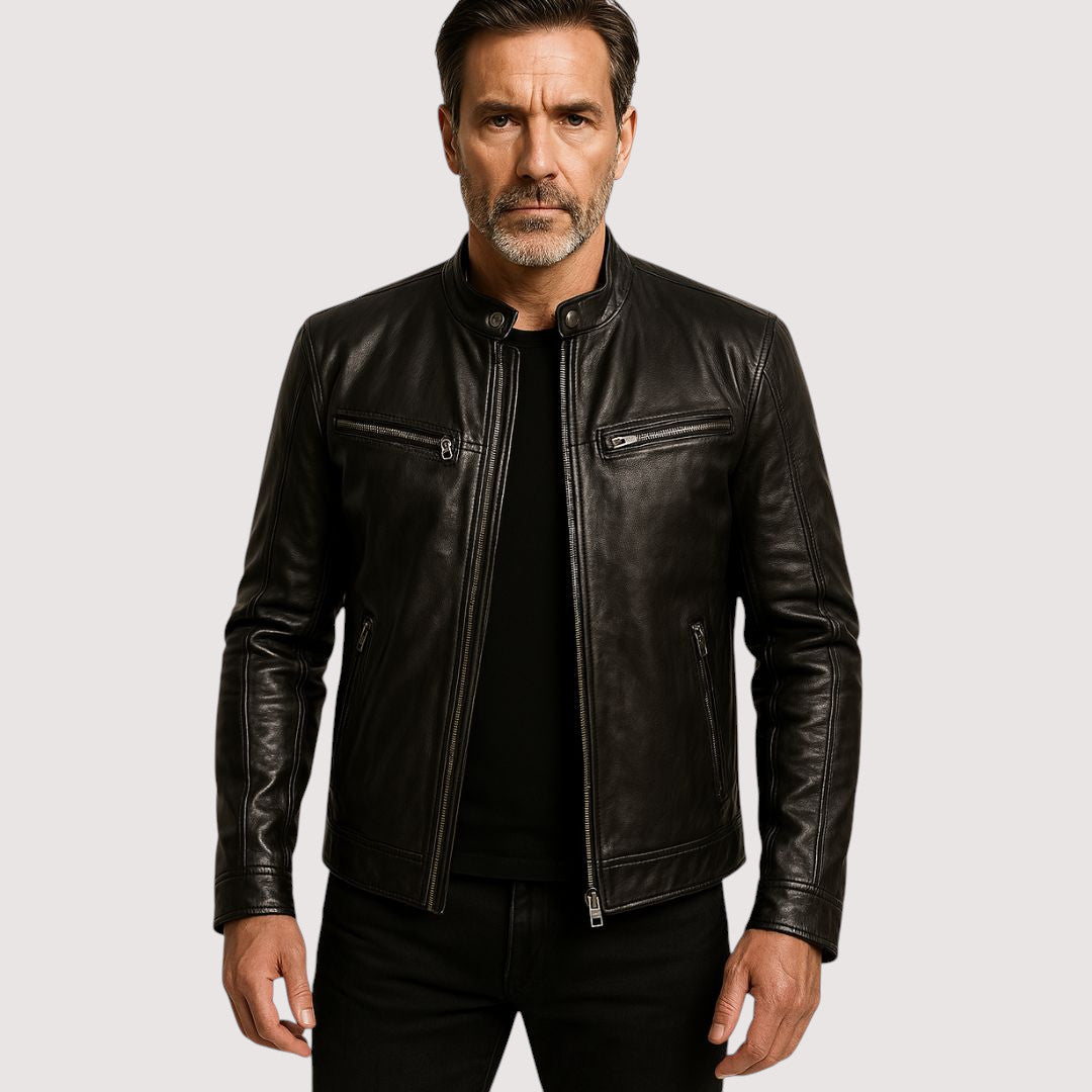Homme à la barbe grisonnante portant la veste noire zippée ouverte sur un t-shirt noir 1