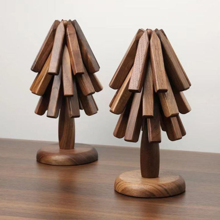 Deux supports en forme de sapin en noyer, chargés de dessous de plat dépliables, posés côte à côte sur une table. 2