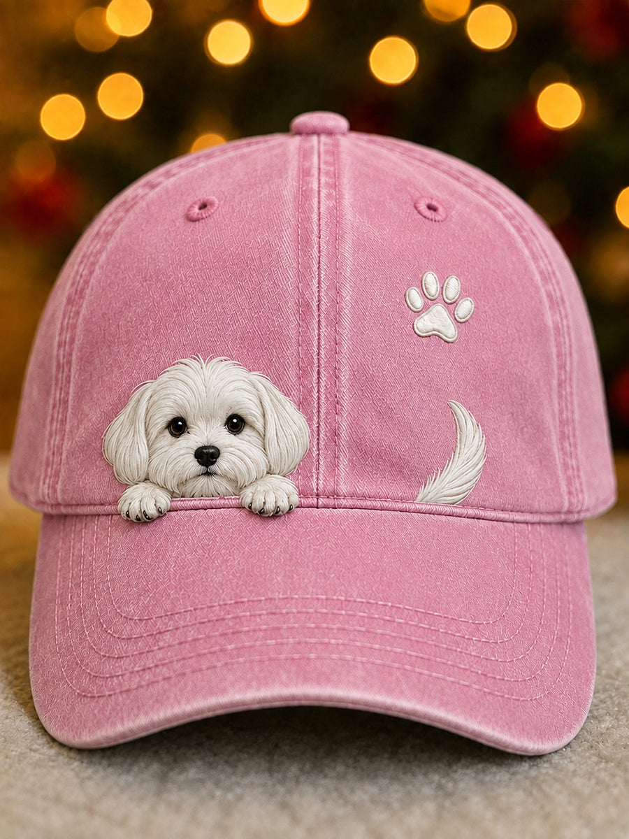 Vue de face de la casquette rose délavée avec un chiot blanc en relief, une empreinte de patte et une queue brodées. 2