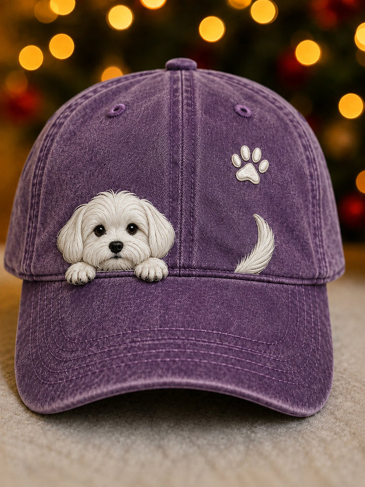 Vue de face de la casquette violette délavée avec un chiot blanc qui regarde au-dessus de la visière, une empreinte de patte et une queue. 7