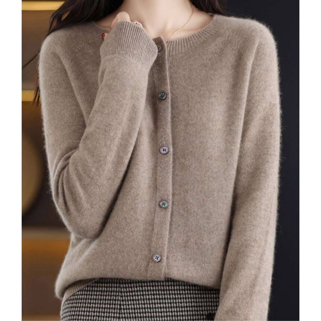 Cardigan taupe à col rond et boutons nacrés, porté sur une jupe à motif pied-de-poule, vue rapprochée de la maille. 10