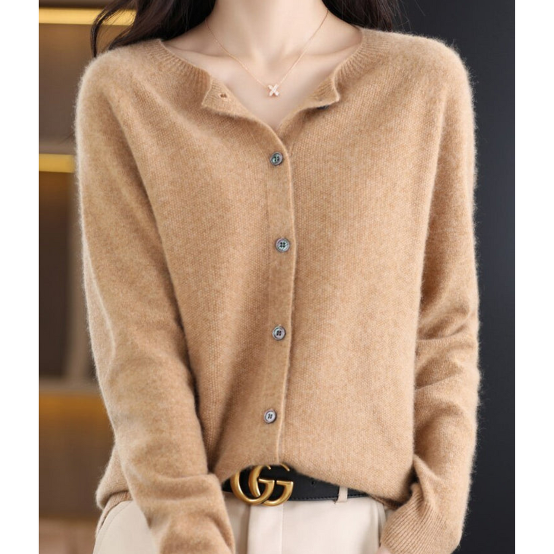 Cardigan camel à col rond et boutons gris, porté avec un pantalon crème et une ceinture noire. 11