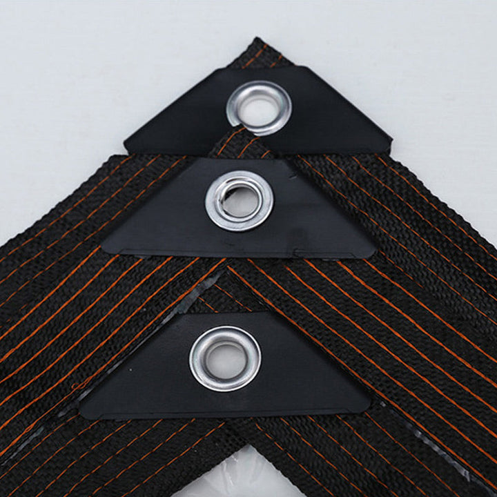 Détail de trois œillets métalliques sur des renforts triangulaires noirs, bordure tissée noire à coutures orange. 5