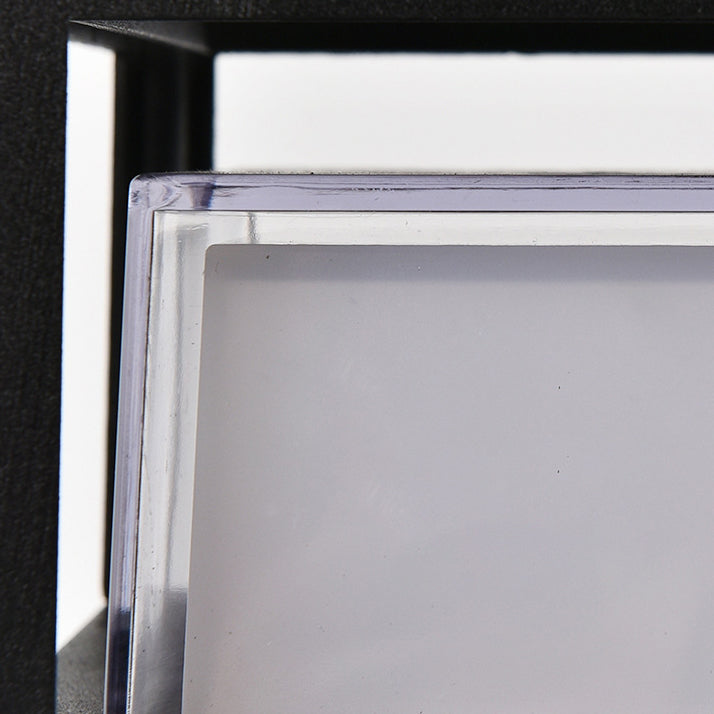 Détail du diffuseur en plastique transparent à bord épais, vu de près derrière le cadre noir de la lampe. 6