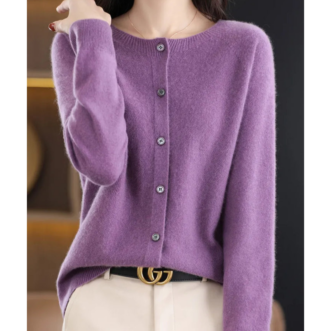 Cardigan violet lilas à col rond et cinq boutons, porté avec un pantalon beige et une ceinture noire. 9