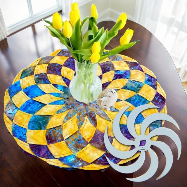 Vue de dessus d'un set de table en patchwork jaune, bleu et violet sous un vase de tulipes jaunes, avec le gabarit blanc en spirale. 13