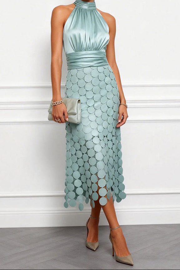 Robe midi vert d'eau à col licou, corsage en satin et jupe de disques, portée avec une pochette assortie et des escarpins. 2
