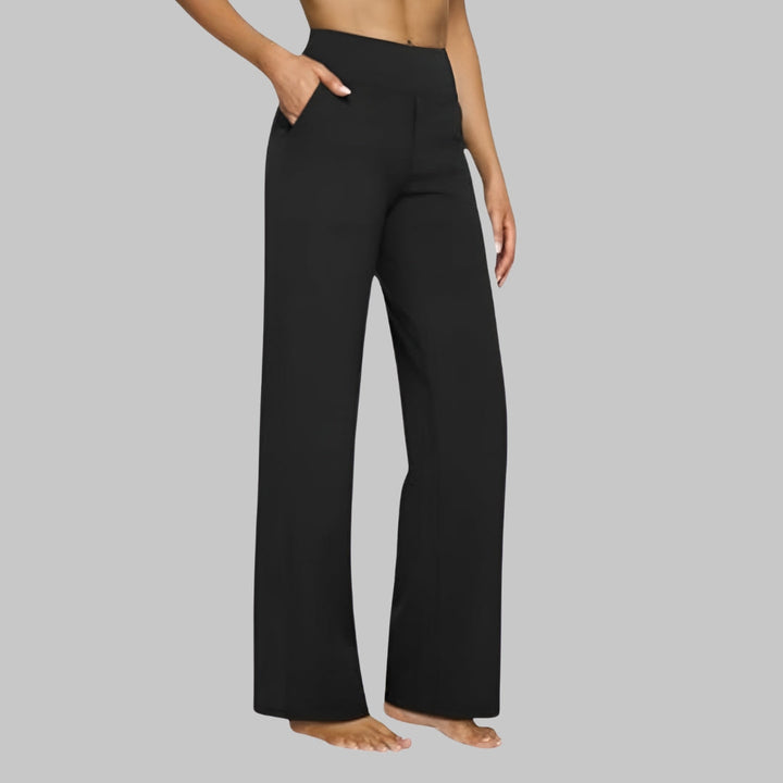 Pantalon noir à taille haute vu de trois quarts, porté par une femme pieds nus, une main dans la poche. 9