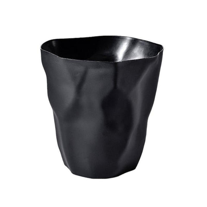 Poubelle noire mate aux plis irréguliers imitant du papier froissé, vue de face sur fond blanc. 1
