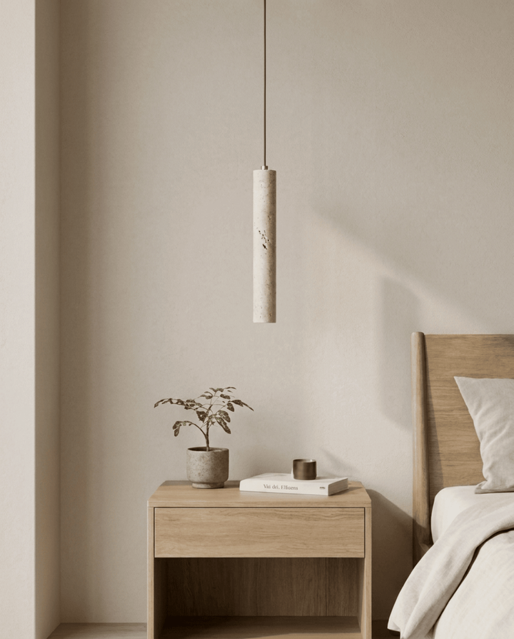 Suspension cylindrique en pierre éteinte au-dessus d'une table de chevet en bois, dans une chambre claire 1
