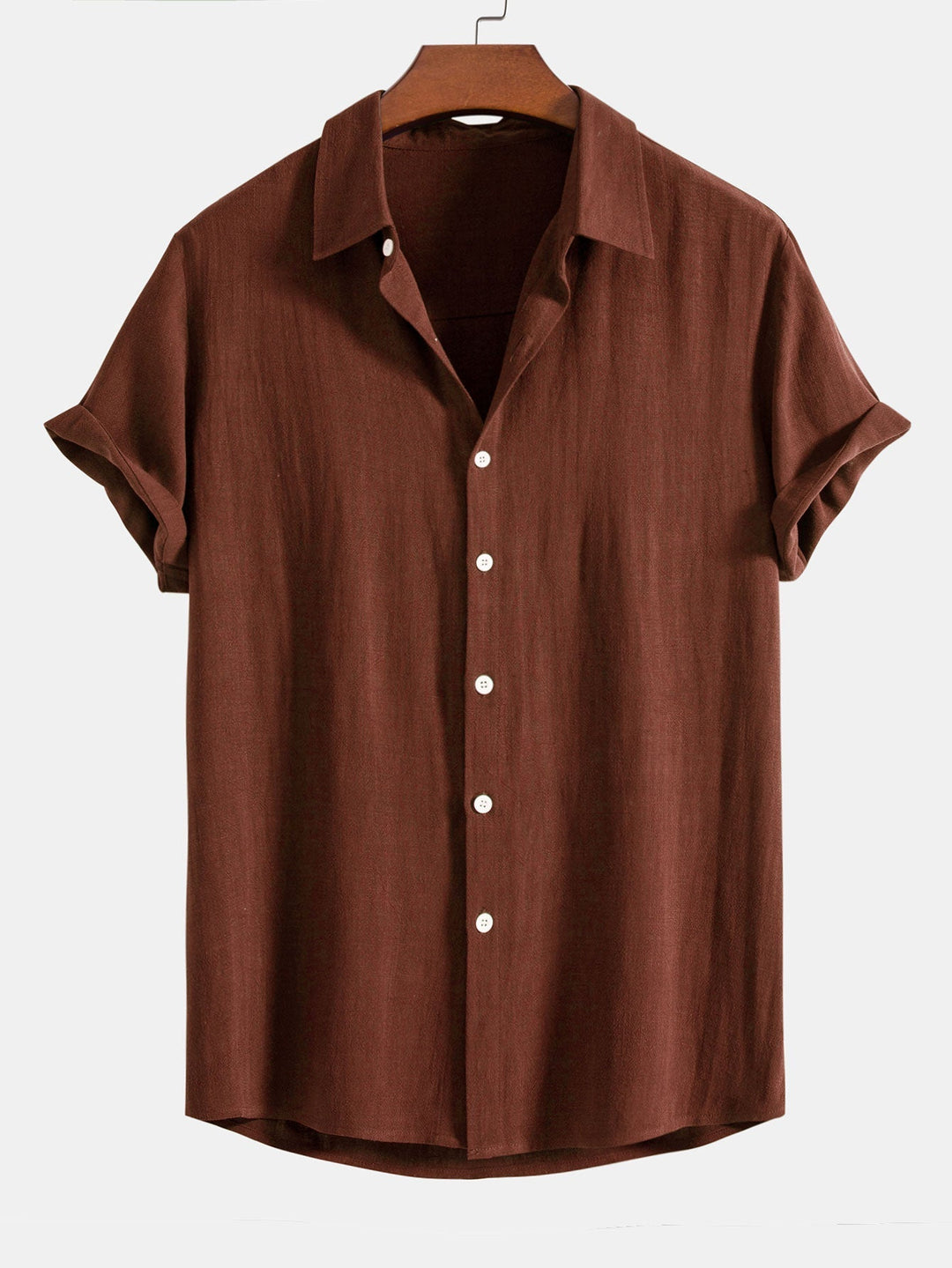 Chemise à manches courtes retroussées, coloris brun roux, sur cintre en bois, vue de face avec boutons blancs. 1