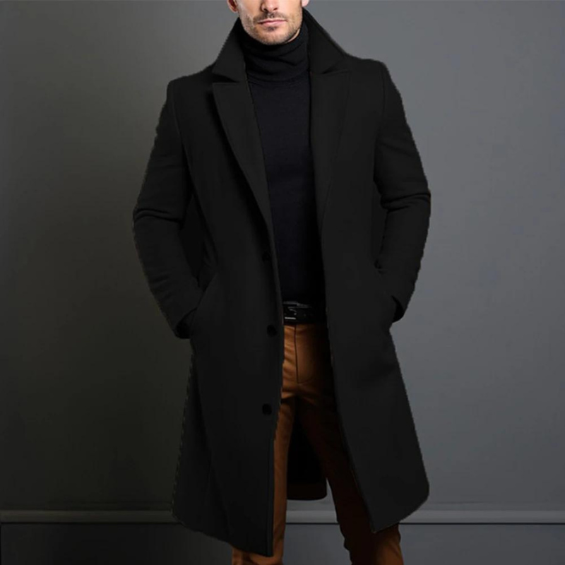 Homme portant le manteau long noir à col cranté et boutons, mains dans les poches, avec col roulé noir et pantalon marron. 1