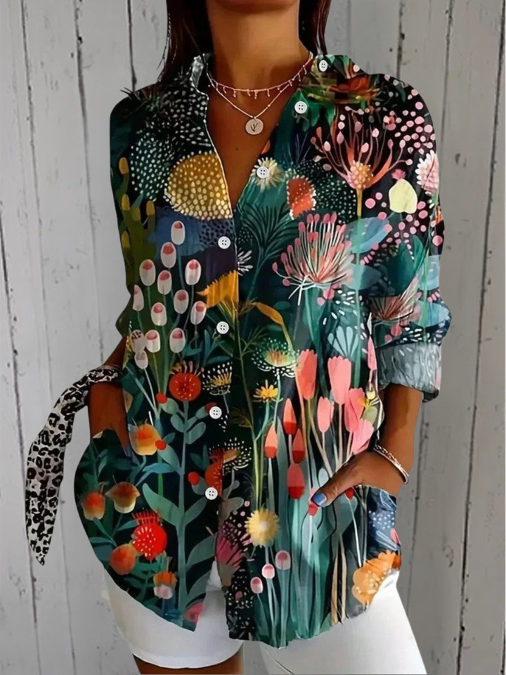 Blouse portée avec un short blanc, motif de plantes et fleurs stylisées colorées sur fond vert foncé. 3