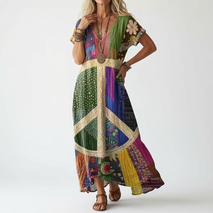 Femme portant la robe à col en V en patchwork coloré, avec un grand symbole de paix beige au centre, sandales marron. 2