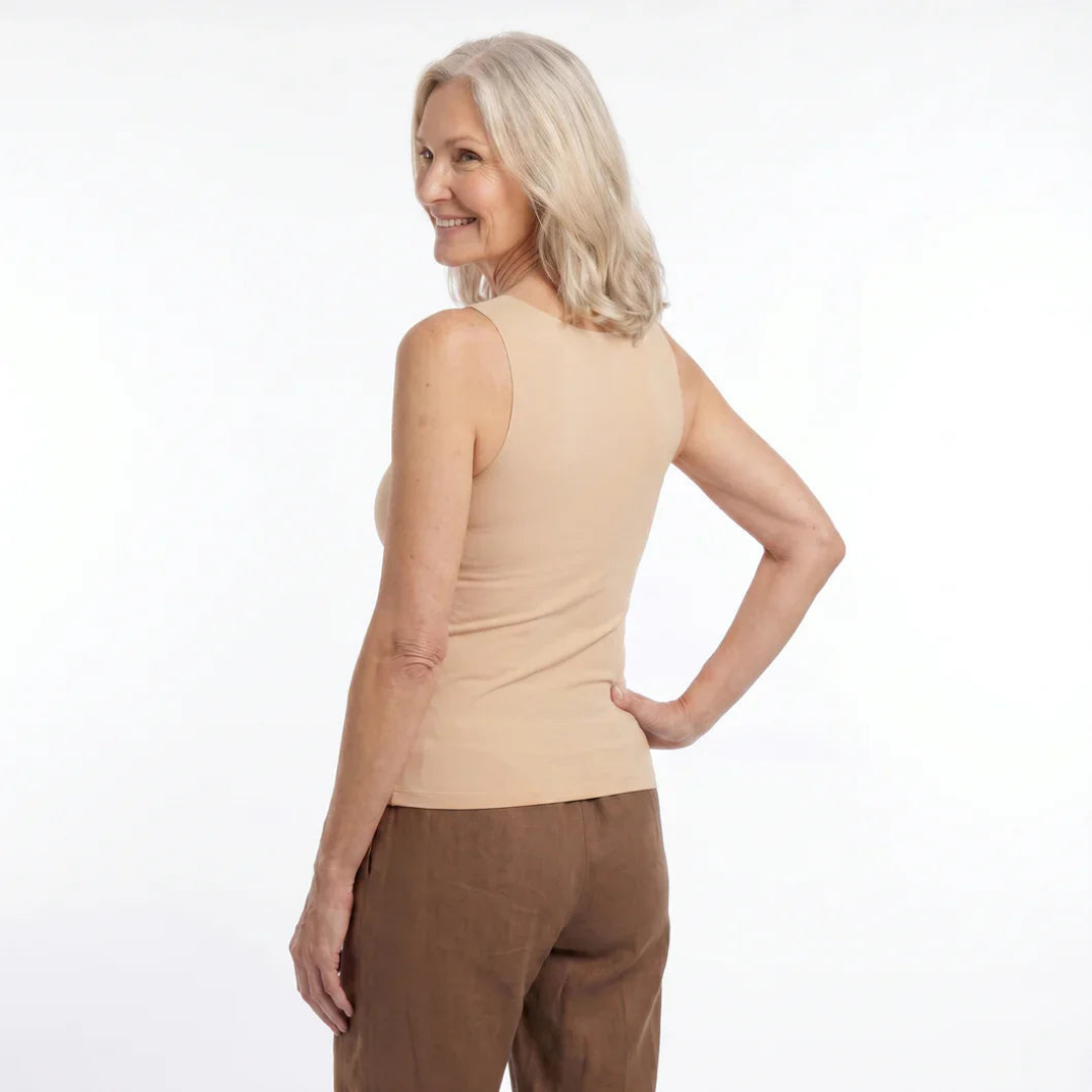 Femme de dos, tournant la tête en souriant, portant le débardeur beige avec un pantalon marron. 6