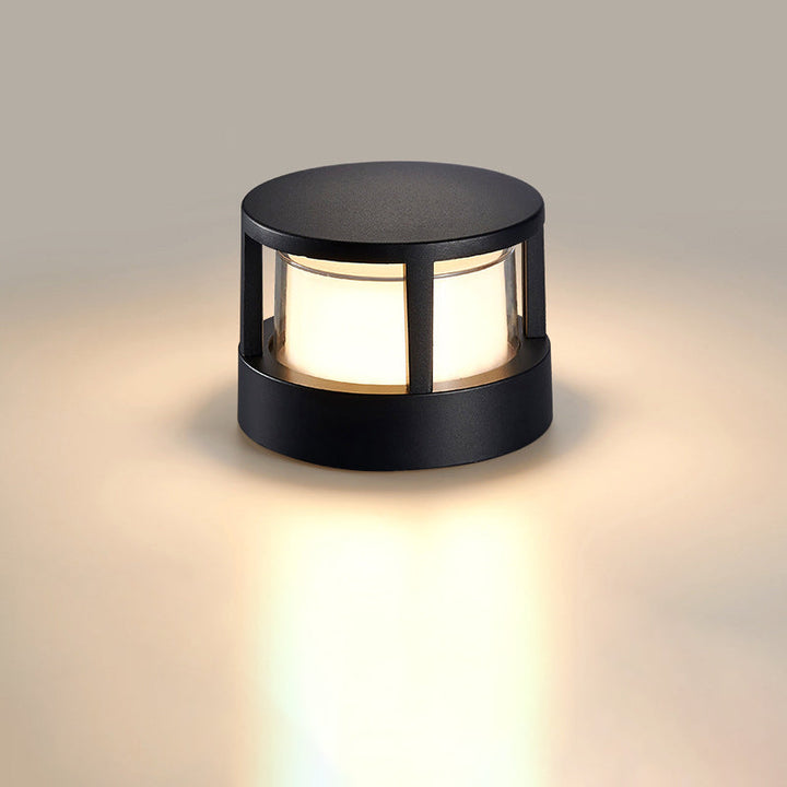 Modèle rond à toit plein, noir, allumé sur fond uni beige avec un halo de lumière chaude au sol. 8