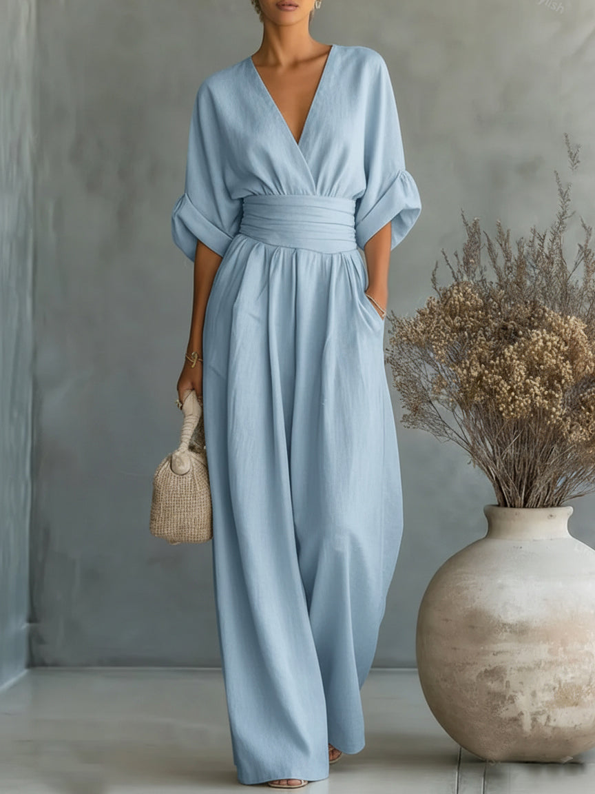 Combinaison bleu clair portée debout, une main dans la poche, bouquet de fleurs séchées à côté 7