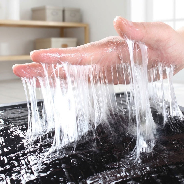 Gros plan sur la colle transparente qui file en longs fils entre les doigts 5