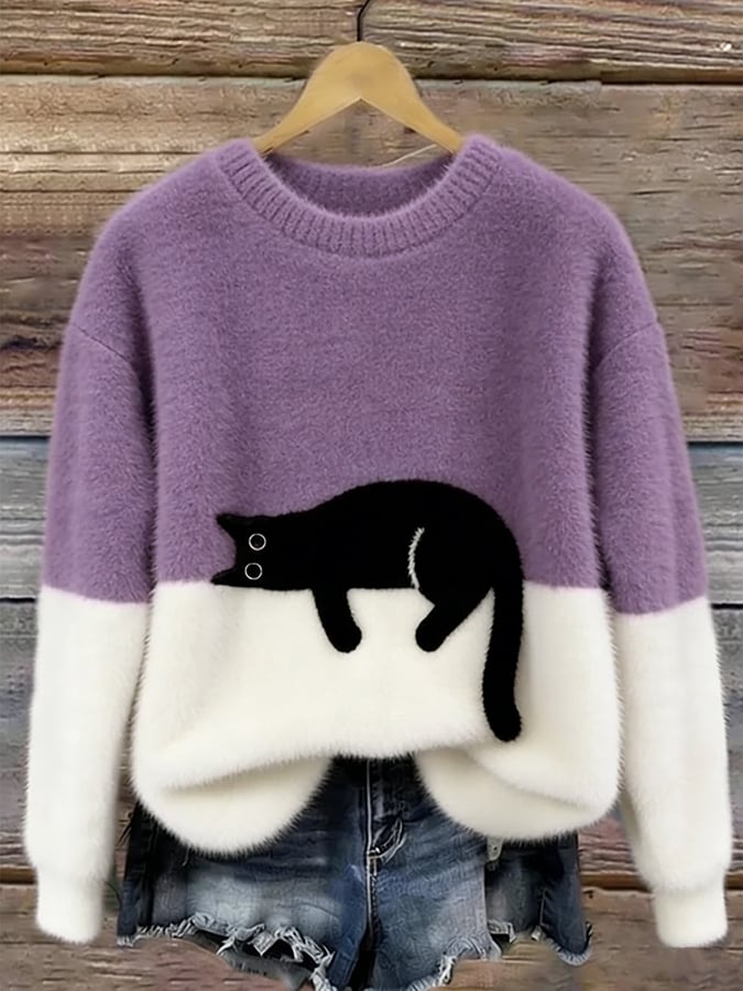 Pull duveteux violet lilas et blanc avec chat noir allongé, présenté sur cintre au-dessus d'un short en jean 10
