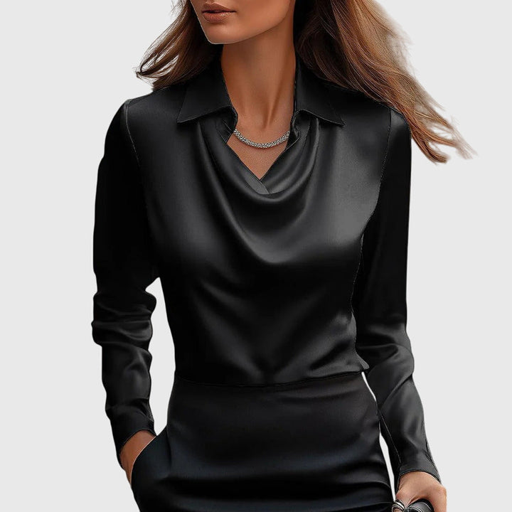 Blouse en satin noir à col drapé et manches longues, portée par un mannequin avec une jupe noire assortie. 3