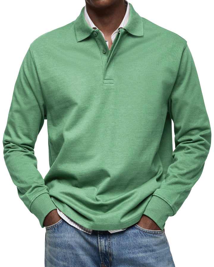 Polo à manches longues vert menthe porté par un homme, mains dans les poches, col classique, chemise rayée dessous et jean. 7