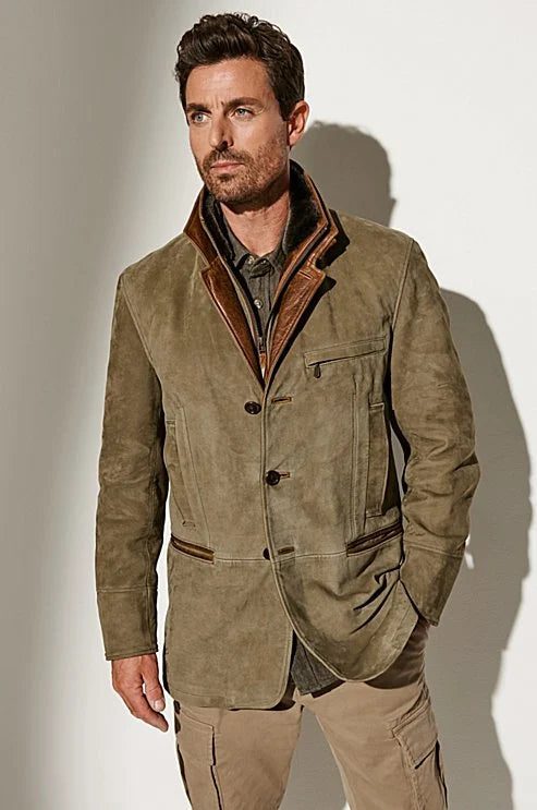 Homme brun en veste de daim vert kaki boutonnée, col doublé de cuir et fourrure, pantalon cargo beige, vue de face. 1