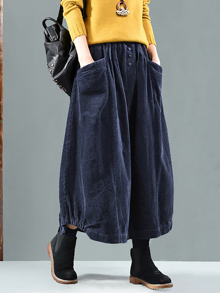 Jupe bleu marine portée de face avec pull jaune, grandes poches et boutons à la taille 4