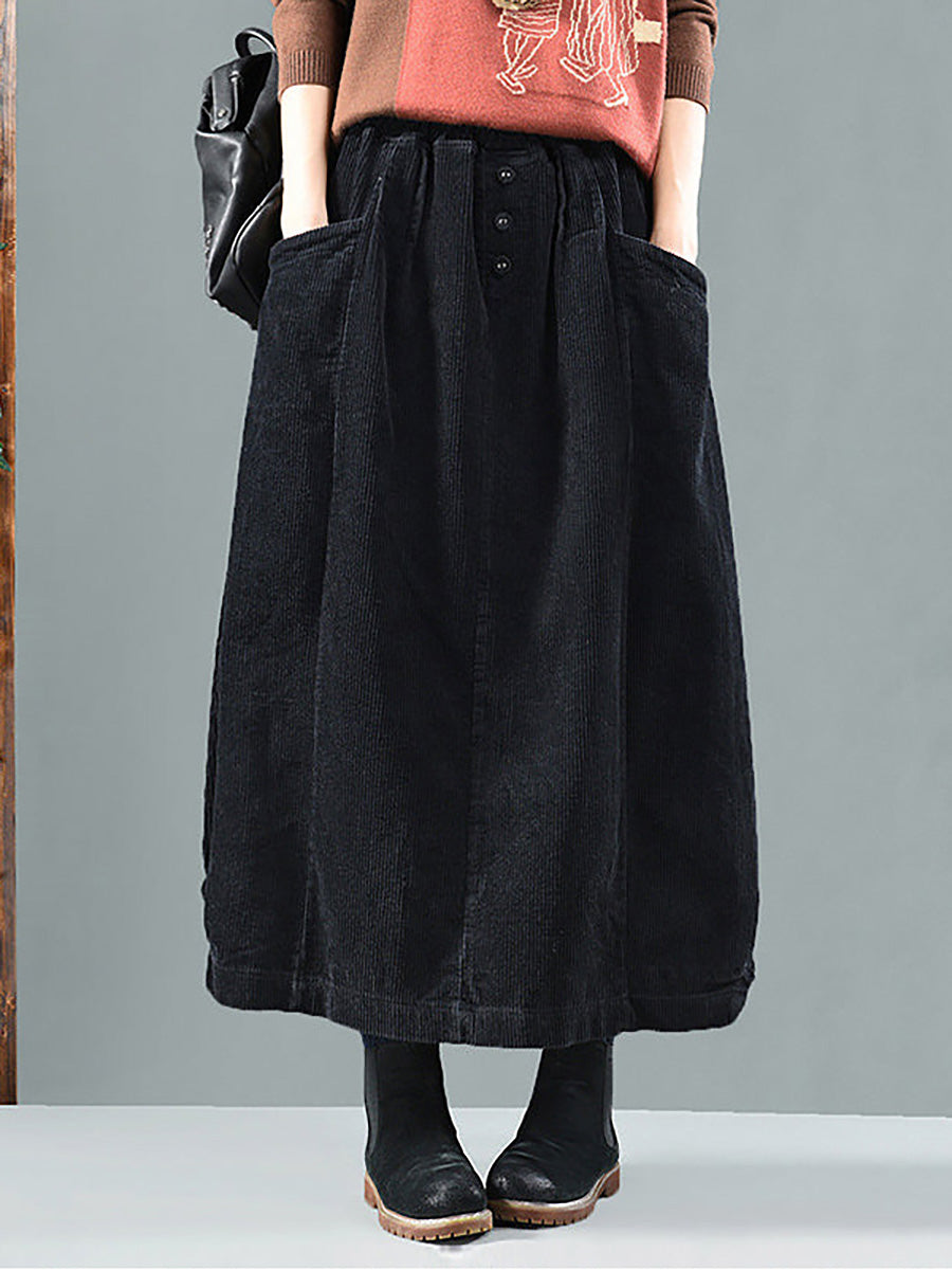 Jupe noire portée de face avec pull orange, grandes poches et trois boutons à la taille 5